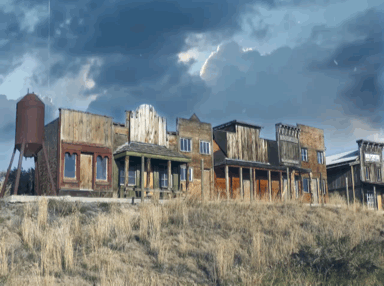 Old film of a ghost town in the old west with a stormy sky. 